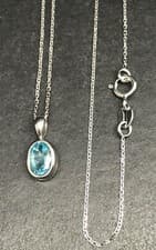 Image of 9ct white gold blue topaz pendant oval 7 x 5mm. 18” chain. New. Gift box.