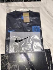 Image of a black Nike England 2025 away football shirt with a blue swoosh and crest