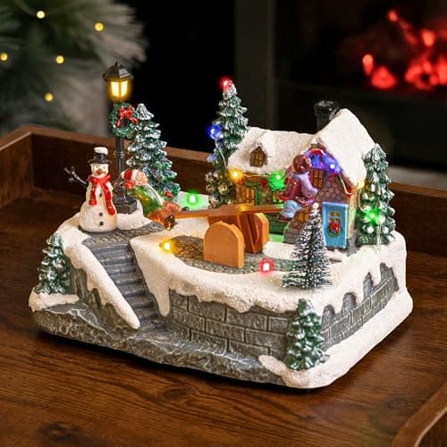 Image of Marco Paul Animated See-Saw Christmas Village Scene - Large 15cm Musical Christmas Ornaments with Multi-Coloured LED Lights - Battery Operated Light Up Xmas Ornaments